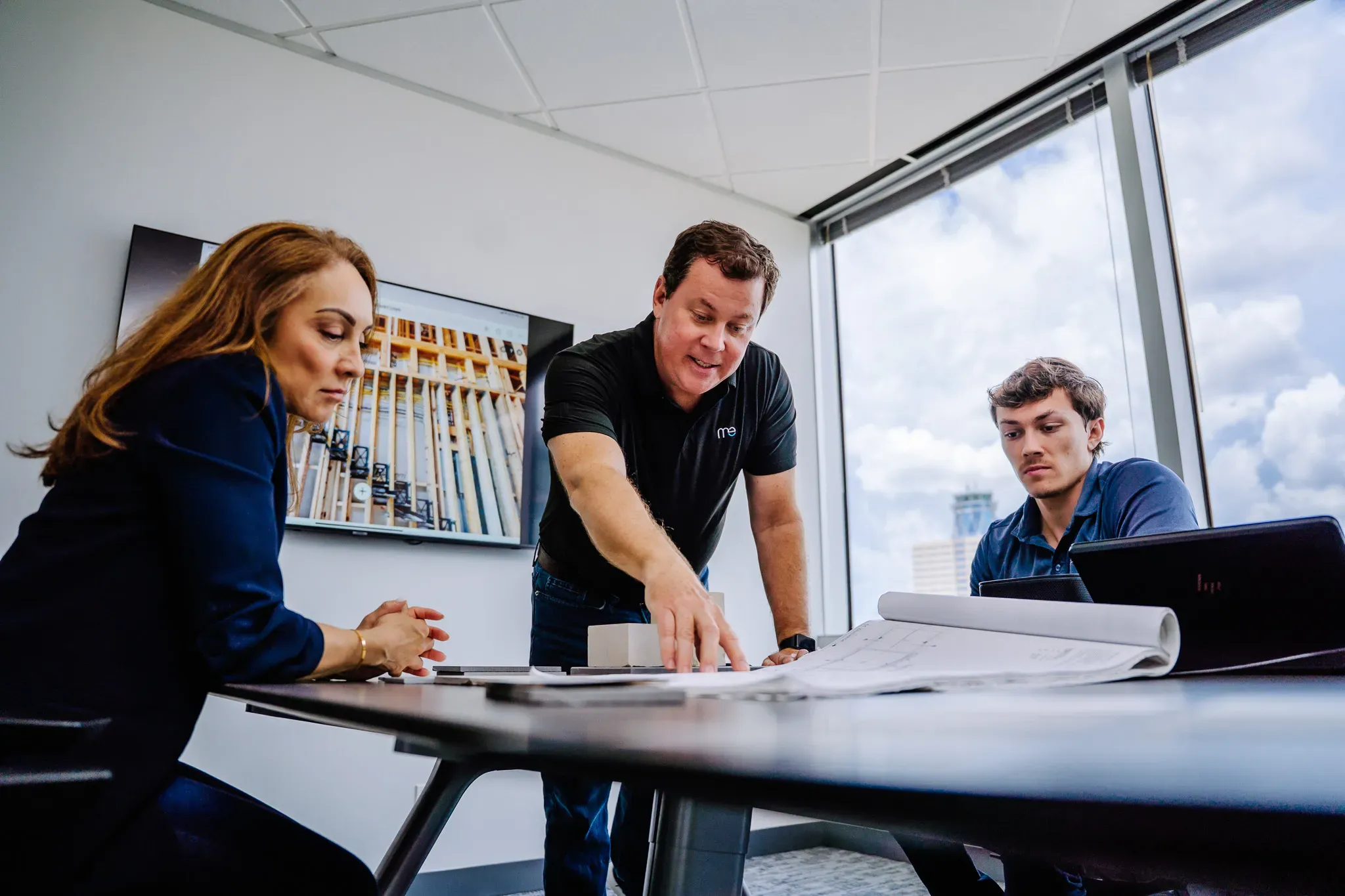 Modern Edge Builders team collaborating around project drawings