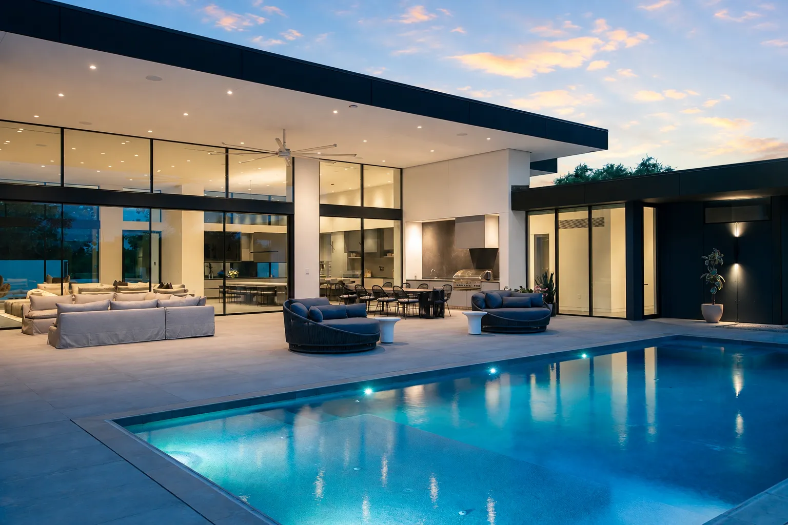 Completed Modern Edge residence at dusk, its living spaces opening onto the terrace and pool
