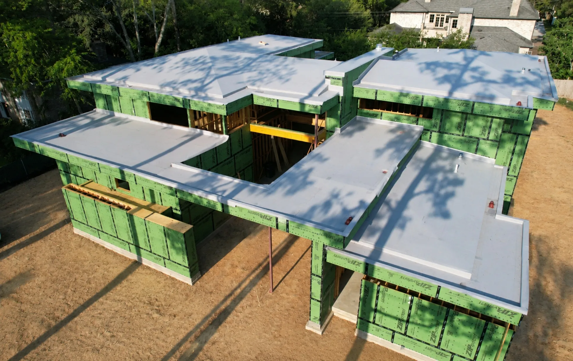 Aerial view of a Modern Edge residence under construction with its roof geometry and enclosure in progress
