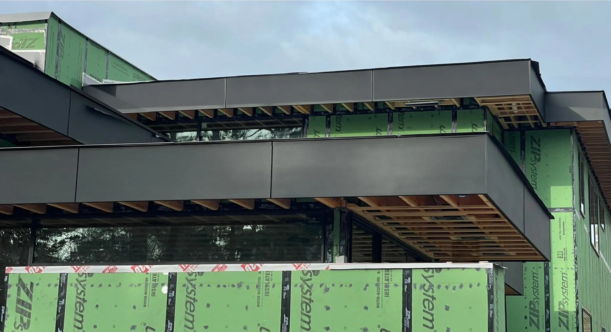 Integrated enclosure system with continuous taped sheathing and window transitions